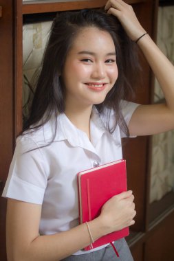 Taylandlı yetişkin öğrenci üniforması güzel kız rahatla ve gülümse.