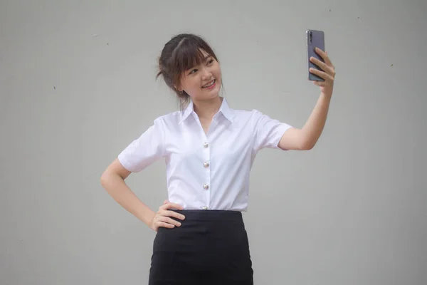 タイのポートレート大人学生大学制服美しいです女の子使用して彼女のスマートフォンSelfie — ストック写真