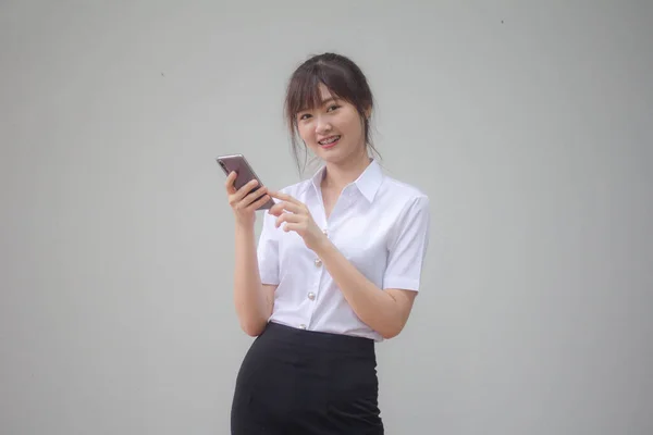 자신의 스마트폰을 사용하는 타이성 대학생 유니폼을 아름다운 소녀의 — 스톡 사진