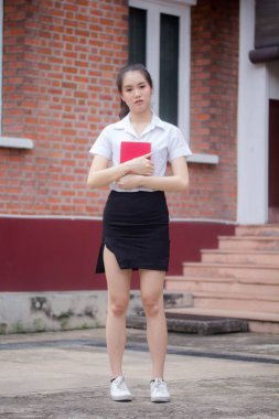 Taylandlı yetişkin öğrenci üniforması güzel kız rahatla ve gülümse.