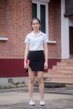 Taylandlı yetişkin öğrenci üniforması güzel kız rahatla ve gülümse.