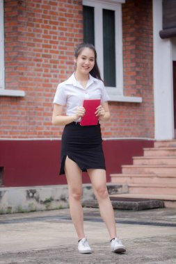 Taylandlı yetişkin öğrenci üniforması güzel kız rahatla ve gülümse.