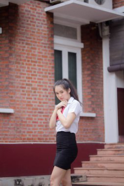 Taylandlı yetişkin öğrenci üniforması güzel kız rahatla ve gülümse.