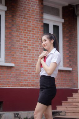 Taylandlı yetişkin öğrenci üniforması güzel kız rahatla ve gülümse.