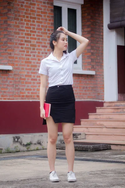 Taylandlı yetişkin öğrenci üniforması güzel kız rahatla ve gülümse.