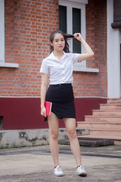 Taylandlı yetişkin öğrenci üniforması güzel kız rahatla ve gülümse.