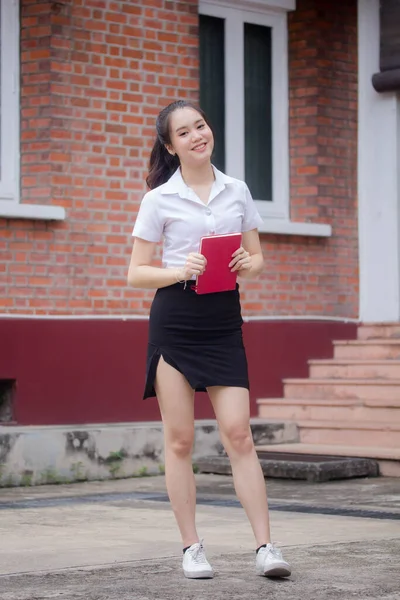 Taylandlı yetişkin öğrenci üniforması güzel kız rahatla ve gülümse.