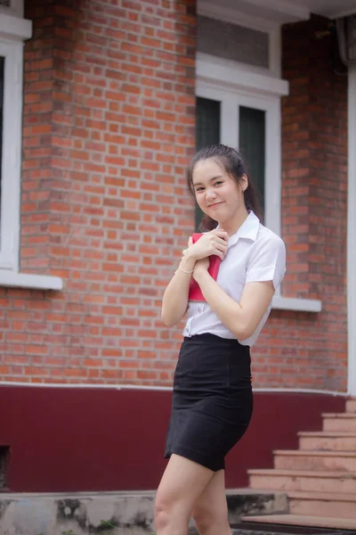 Taylandlı yetişkin öğrenci üniforması güzel kız rahatla ve gülümse.