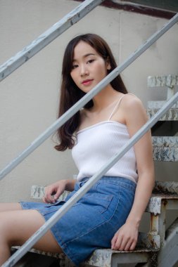 Tayland portresi yetişkin güzel kız beyaz gömlek mavi kot rahatla ve gülümse