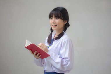 Asya Thai Lisesi üniformalı güzel kız. Bir kitap yaz.