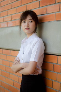 Taylandlı yetişkin öğrenci üniforması portresi. Güzel kız rahatla ve gülümse.