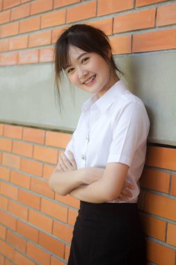 Taylandlı yetişkin öğrenci üniforması portresi. Güzel kız rahatla ve gülümse.