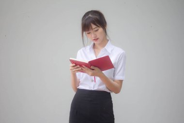 Taylandlı yetişkin öğrenci üniforması portresi. Güzel kız kırmızı kitabı okudu.