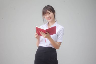 Taylandlı yetişkin öğrenci üniforması portresi. Güzel kız kırmızı kitabı okudu.