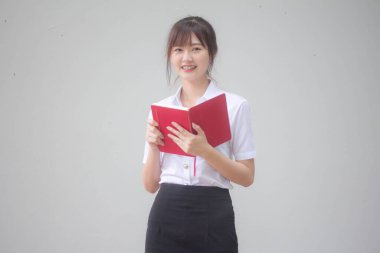 Taylandlı yetişkin öğrenci üniforması portresi. Güzel kız kırmızı kitabı okudu.