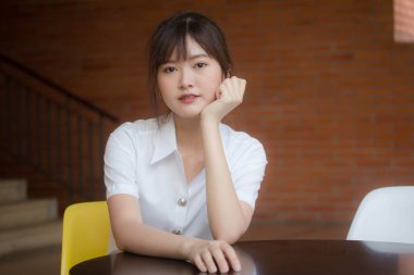 Taylandlı yetişkin öğrenci üniforması portresi. Güzel kız rahatla ve gülümse.