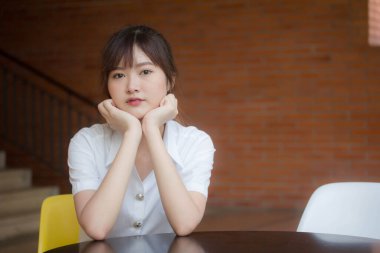 Taylandlı yetişkin öğrenci üniforması portresi. Güzel kız rahatla ve gülümse.