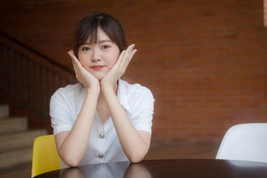 Taylandlı yetişkin öğrenci üniforması portresi. Güzel kız rahatla ve gülümse.