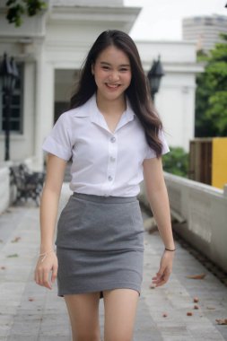 Taylandlı yetişkin üniversite üniforması güzel kız rahatla ve gülümse..