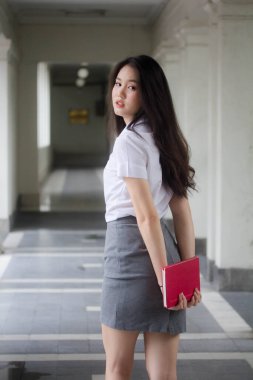 Taylandlı yetişkin üniversite üniforması güzel kız rahatla ve gülümse..