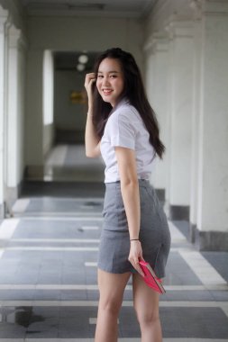 Taylandlı yetişkin üniversite üniforması güzel kız rahatla ve gülümse..