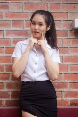 Taylandlı yetişkin öğrenci üniforması güzel kız rahatla ve gülümse.