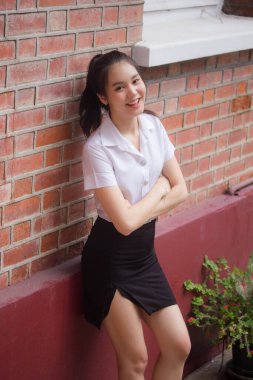 Taylandlı yetişkin öğrenci üniforması güzel kız rahatla ve gülümse.