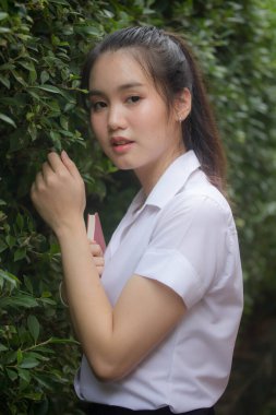 Taylandlı yetişkin öğrenci üniforması güzel kız rahatla ve gülümse.