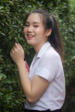 Taylandlı yetişkin öğrenci üniforması güzel kız rahatla ve gülümse.