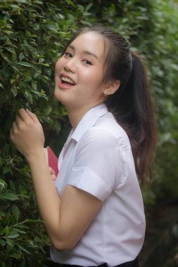 Taylandlı yetişkin öğrenci üniforması güzel kız rahatla ve gülümse.