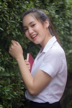 Taylandlı yetişkin öğrenci üniforması güzel kız rahatla ve gülümse.