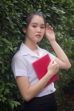 Taylandlı yetişkin öğrenci üniforması güzel kız rahatla ve gülümse.