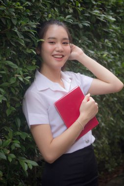 Taylandlı yetişkin öğrenci üniforması güzel kız rahatla ve gülümse.