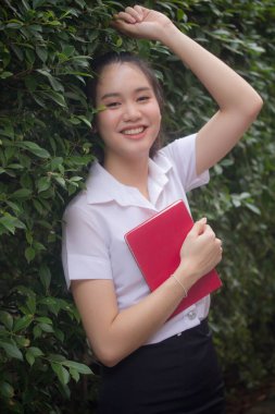 Taylandlı yetişkin öğrenci üniforması güzel kız rahatla ve gülümse.