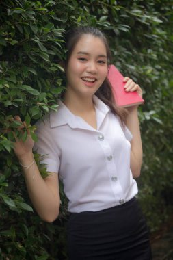 Taylandlı yetişkin öğrenci üniforması güzel kız rahatla ve gülümse.