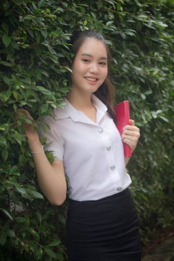 Taylandlı yetişkin öğrenci üniforması güzel kız rahatla ve gülümse.