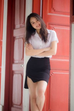 Taylandlı yetişkin öğrenci üniforması güzel kız rahatla ve gülümse.