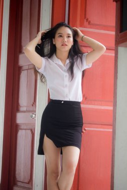 Taylandlı yetişkin öğrenci üniforması güzel kız rahatla ve gülümse.