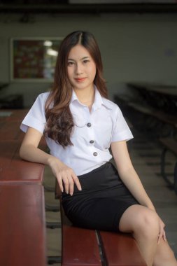 Taylandlı yetişkin öğrenci üniforması güzel kız rahatla ve gülümse.