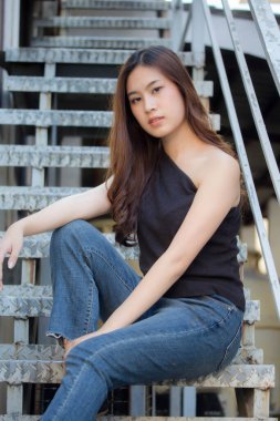 Tayland portresi yetişkin güzel kız siyah gömlek mavi kot pantolon rahatla ve gülümse