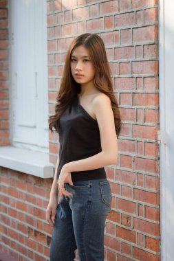 Tayland portresi yetişkin güzel kız siyah gömlek mavi kot pantolon rahatla ve gülümse