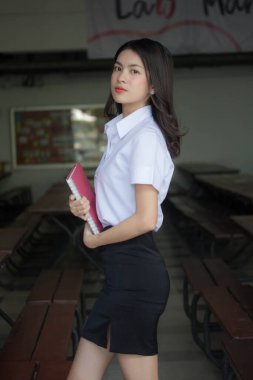 Taylandlı yetişkin öğrenci üniforması güzel kız rahatla ve gülümse.