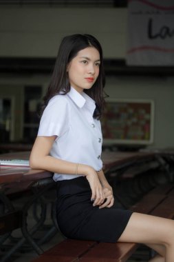 Taylandlı yetişkin öğrenci üniforması güzel kız rahatla ve gülümse.