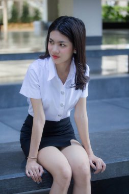 Taylandlı yetişkin öğrenci üniforması güzel kız rahatla ve gülümse.