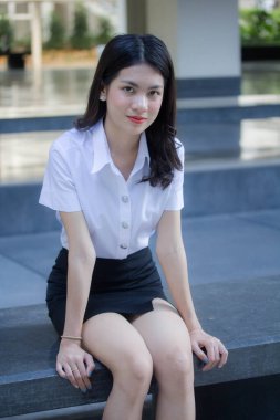 Taylandlı yetişkin öğrenci üniforması güzel kız rahatla ve gülümse.