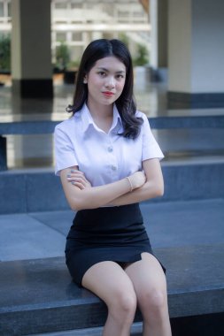 Taylandlı yetişkin öğrenci üniforması güzel kız rahatla ve gülümse.