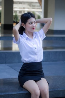 Taylandlı yetişkin öğrenci üniforması güzel kız rahatla ve gülümse.