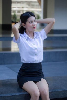 Taylandlı yetişkin öğrenci üniforması güzel kız rahatla ve gülümse.