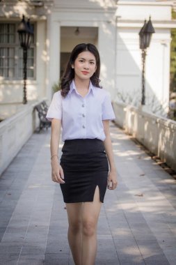 Taylandlı yetişkin öğrenci üniforması güzel kız rahatla ve gülümse.