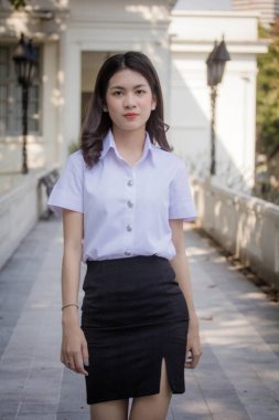 Taylandlı yetişkin öğrenci üniforması güzel kız rahatla ve gülümse.